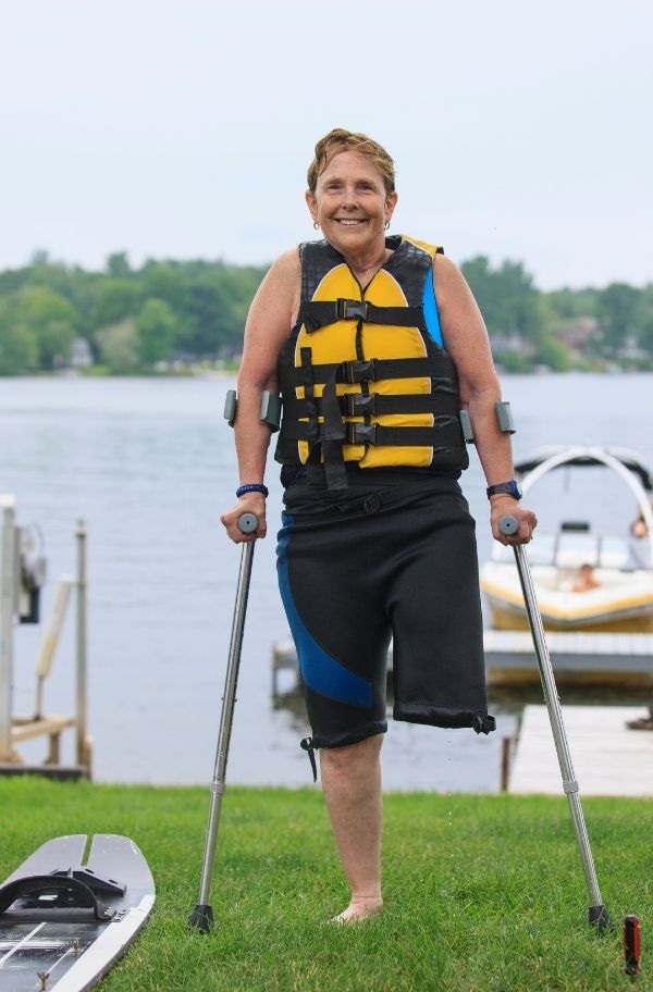 Person wih one leg wearing life jacket ready to go water skiing